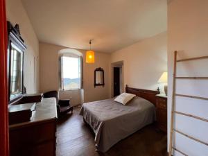 a bedroom with a bed and a chair and a window at Maison d'Americains Lapedina in Pietracorbara