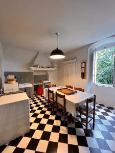 a kitchen with a table and a checkered floor at Maison d'Americains Lapedina in Pietracorbara