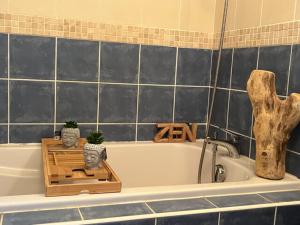 een badkamer met een bad met een houten kist en planten bij Villa Cool Douce in Joyeuse