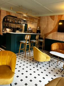 a restaurant with yellow chairs and a bar at Hôtel De Londres in Menton