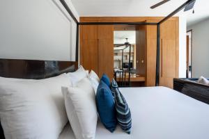 バンタオビーチにあるTwo Bedroom Wings Pool Villaのベッドルーム(白いベッド、青い枕付)