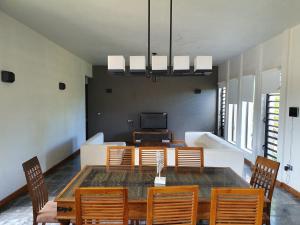 ein Esszimmer mit einem Tisch, Stühlen und einem TV in der Unterkunft Stunning and Luxurious Villa at Royal Park Balaclava in Balaclava