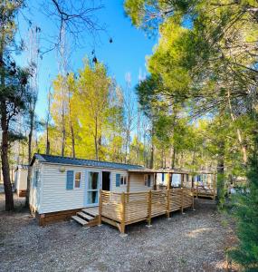 a tiny house in the woods with a porch at Camping la Peiriere in Tuchan