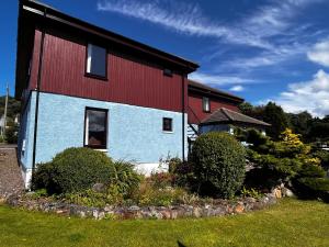 a house with a red and blue paint on it at Snowgoose Apartments & Bunkhouse in Fort William