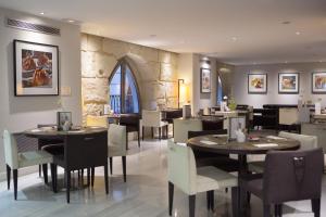 a restaurant with tables and chairs and a stone wall at Hospes Amérigo, Alicante, a Member of Design Hotels in Alicante