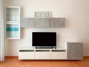 a living room with a tv on a white entertainment center at Adamo ed Eva Resort in Numana