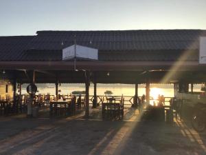 un edificio con mesas y sillas frente al agua en Pon's Riverside Guesthouse en Muang Không