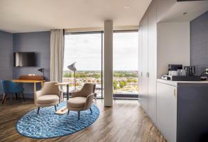 a kitchen and living room with a table and chairs at Mercure Hotel Amersfoort Centre in Amersfoort