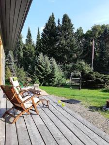 een houten terras met een stoel en een picknicktafel bij Alapihan Arboretumin vierasmaja ja sauna 