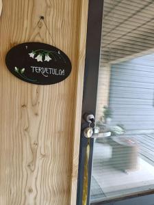 a sign on a wooden door with a window at Alapihan Arboretumin vierasmaja ja sauna 