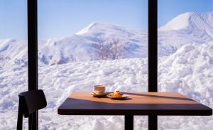 a table with a cup of coffee and a plate of food at Alpina Hotel in Gudauri