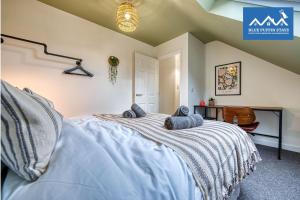 una camera da letto con un letto con cuscini blu di 4 Bed Design House, 2 Off-road Parking Spaces, Great for Groups - Central Gloucester By Blue Puffin Stays a Gloucester