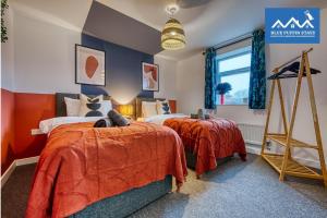 2 camas en una habitación con paredes rojas y azules en 4 Bed Design House, 2 Off-road Parking Spaces, Great for Groups - Central Gloucester By Blue Puffin Stays en Gloucester