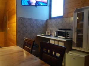 a small kitchen with a table and a microwave at Apartamenty i pokoje gościnne Nowita in Zakopane