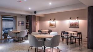 a restaurant with tables and chairs in a room at Alpina Hotel in Gudauri