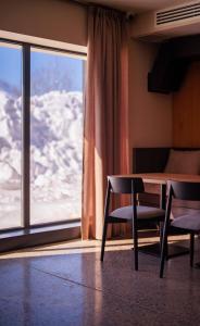 a room with a table and two chairs and a window at Alpina Hotel in Gudauri