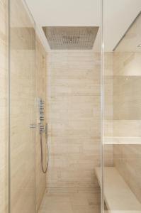a bathroom with a shower with a glass door at Roomers Baden-Baden, Autograph Collection in Baden-Baden