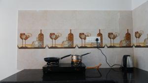 a counter with a stove with vases on shelves at Angela's Boutique Homes Dharamkot in Dharamshala