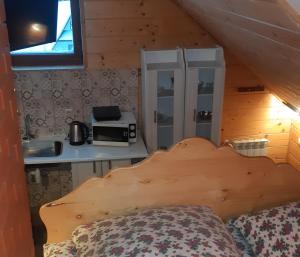a bedroom with a bed and a kitchen in a cabin at Apartamenty i pokoje gościnne Nowita in Zakopane