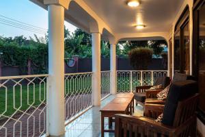 a porch with chairs and a table on a balcony at Dreamer's Holiday Home Arusha in Arusha