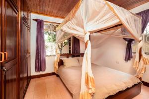 a bedroom with a canopy bed in a room at Dreamer's Holiday Home Arusha in Arusha