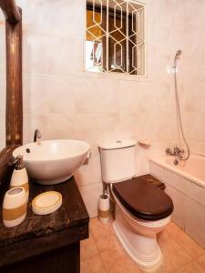 a bathroom with a toilet and a sink and a tub at Dreamer's Holiday Home Arusha in Arusha