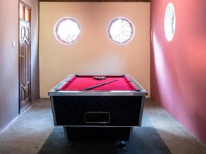 a pool table in a room with two windows at Dreamer's Holiday Home Arusha in Arusha