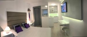 a white room with a bed and a desk and a sink at studio in vila- natural 22 C ! in Breaza de Sus