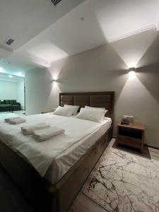 a bedroom with a large bed with towels on it at Hotel Nova in Bishkek