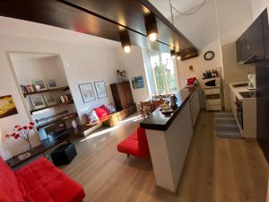 a kitchen and a living room with a red couch at Gardenia in Oggebbio