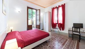 Guest House L'Aranceto في فلورنسا: غرفة نوم بسرير احمر وستائر حمراء