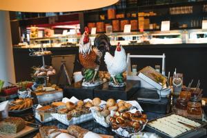 a buffet of food with chickens and bread and pastries at Roomers Baden-Baden, Autograph Collection in Baden-Baden