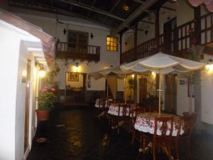 un restaurante con mesas, sillas y sombrillas en Hotel Midori, en Cusco