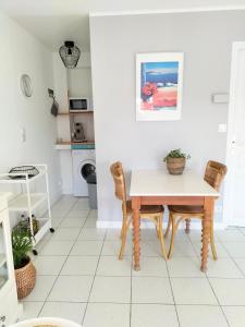 a kitchen with a table and chairs in a room at Charmant Studio à proximité du Port de St Martin de Ré in Saint-Martin-de-Ré