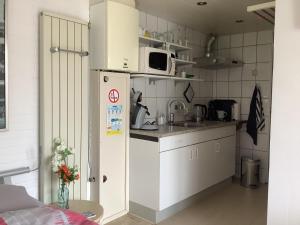 een kleine keuken met een koelkast en een magnetron bij Dekker in Nijverdal