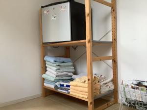 ein Holzregal mit Handtüchern und einem Kühlschrank in der Unterkunft Dekker in Nijverdal