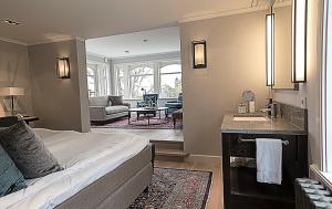 Cet appartement comprend une chambre avec un lit et un lavabo ainsi qu'un salon. dans l'établissement Albert Kök Hotell & Konferens, à Trollhättan