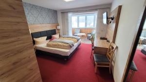 1 dormitorio con 2 camas y alfombra roja en Schwarzes Lamm, en Rothenburg ob der Tauber