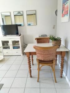 a dining room with a table and chairs and a tv at Charmant Studio à proximité du Port de St Martin de Ré in Saint-Martin-de-Ré