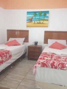 Itapemirim的住宿－Linda casinha na Praia de Itaoca，一间卧室设有两张床,墙上挂着一幅画