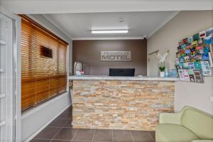 a lobby of a hospital motel with a brick counter at Rosebud Motel in Tootgarook