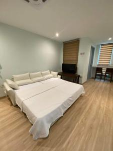 a large white bed in a room with a wooden floor at CT HOME83Stay - Klebang Beach Melaka in Kelebang Besar