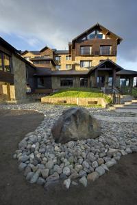 a large rock sitting in front of a house at Imago Hotel & Spa in El Calafate
