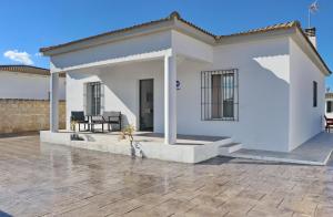 een klein wit huis met een patio bij Chalet Nati in Chiclana de la Frontera