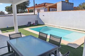 a patio with a table and chairs next to a swimming pool at Chalet Nati in Chiclana de la Frontera