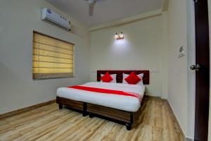 a bedroom with a bed with red pillows on it at OYO Flagship Maple The Residence Near RDB Cinemas in Thākurdwari