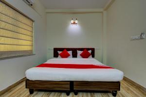 a bedroom with a large bed with red pillows at OYO Flagship Maple The Residence Near RDB Cinemas in Thākurdwari
