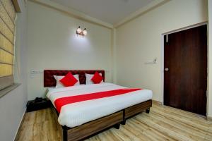 a bedroom with a large bed with red pillows at OYO Flagship Maple The Residence Near RDB Cinemas in Thākurdwari