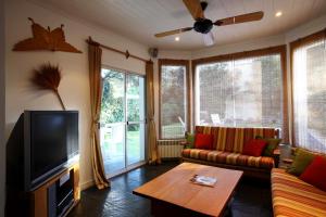 a living room with a couch and a tv at Lo de Costa B&B in Vicente López