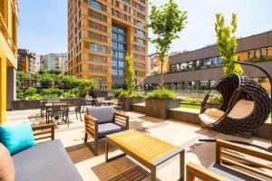 Cebeci Chic and Cosy Apartments في إسطنبول: فناء على السطح مع أرجوحة وطاولات وكراسي